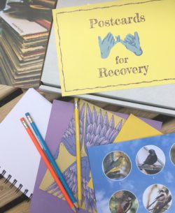 Brightly coloured postcards and pencils scattered on a table