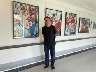 Artist, Patrick Bremer stood in front of his exhibition of works created using collage