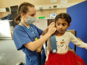 A nurse looking at the child's ear