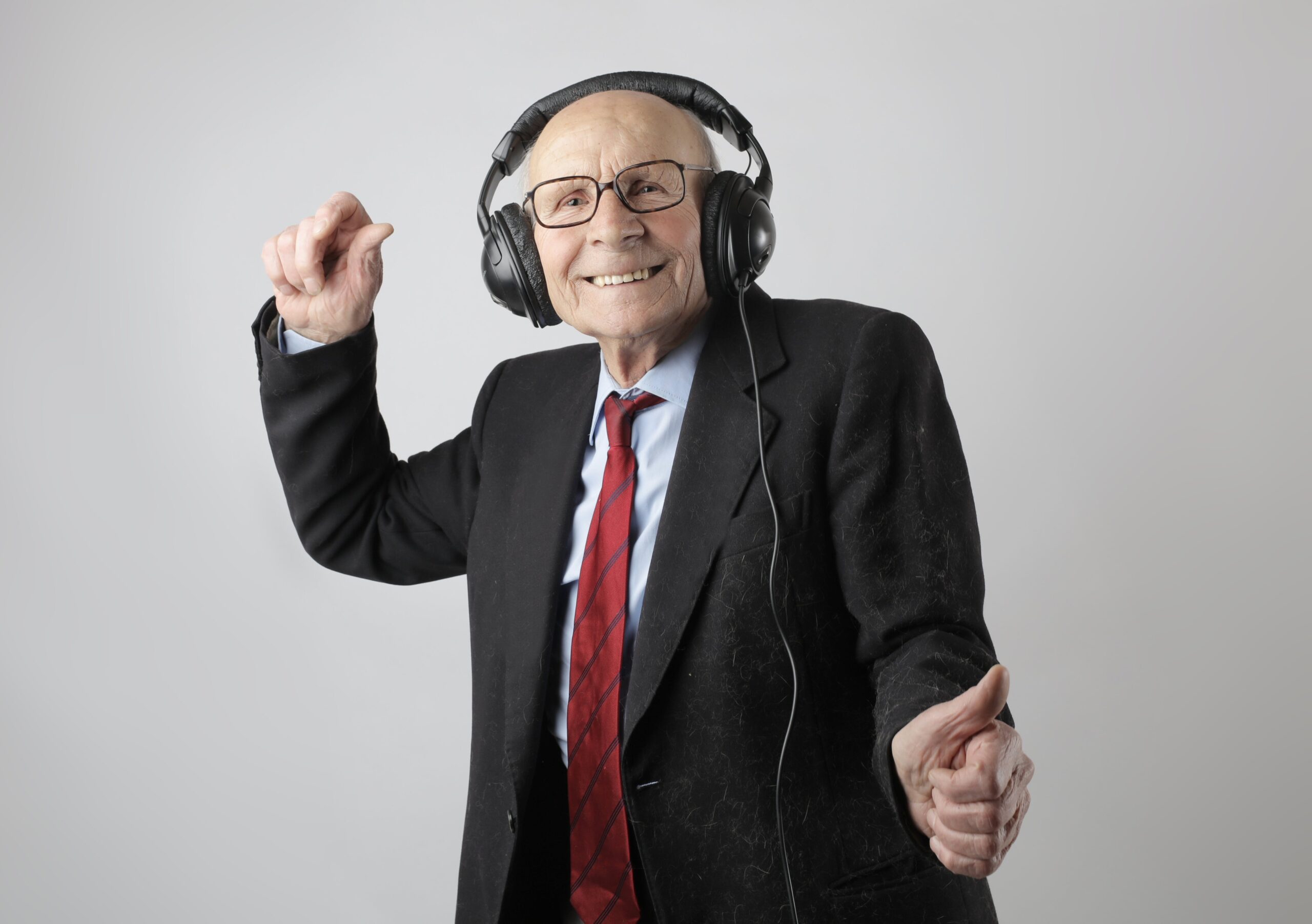 elderly man wearing headphones listening to a podcast