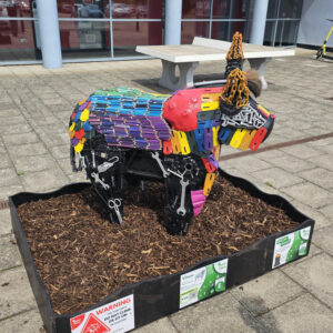 A sculpture of a bull decorated with pencils and brightly-coloured objects