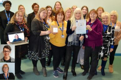 The colleagues who make up the Somerset NHS Foundation Trust carers assessment service stood smiling holding their NHS England award.