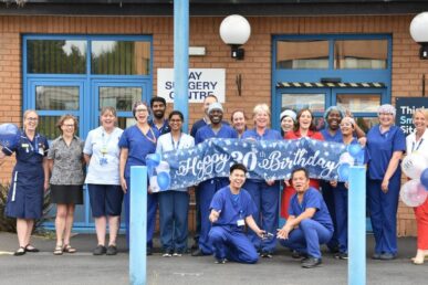 A photo of colleagues at Musgrove Park Hospital's day surgery centre stood outside the building celebrating its 30th anniversary.