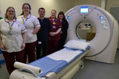 Colleagues who work in the radiology department at Yeovil Hospital are stood next to the hospital's new CT scanner.