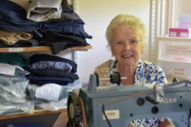A photo of seamstress Helen McDermaid with a sewing machine at Williton Hospital.