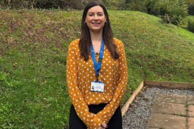 A photo of psychological wellbeing practitioner Dawn Murray standing outside in a garden.