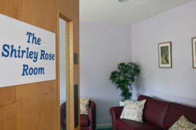 A photo of the door to the Shirley Rose Room at Williton Hospital, which has a sign saying