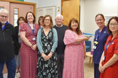 A photo of colleagues and the family who fundraised for the new relatives' room on Dunkery stroke unit at Musgrove Park Hospital cutting the ribbon to officially open the room.