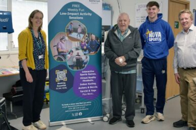 A photo of four people stood next to an immersive projector at Musgrove Park Hospital's discharge lounge.