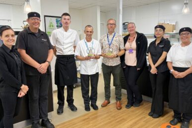 A group of people in Yeovil Hospital's catering team standing in the hospital canteen.