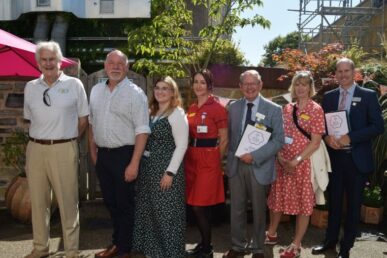 A photo of colleagues at Yeovil Hospital standing with judges from the Yeovil in Bloom contest. The photo has been taken in front of the hospital's dementia garden.