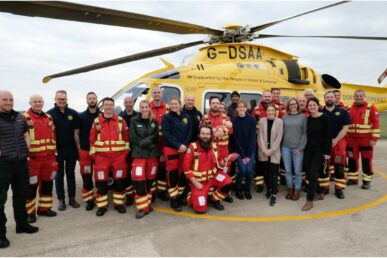 A group of colleagues at Somerset NHS Foundation Trust's maternity department stood with colleagues from the Dorset and Somerset Air Ambulance, next to a helicopter.