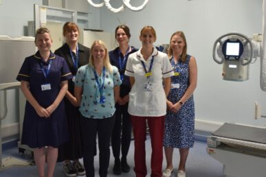 A group of colleagues in standing in a clinic room.