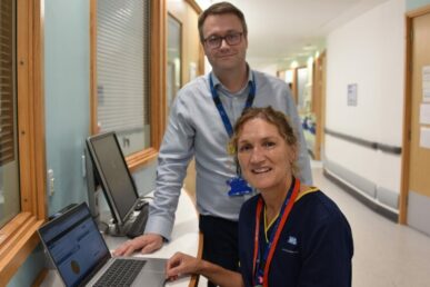 A photo of two people next to a computer in a ward corridor at Musgrove Park Hospital.