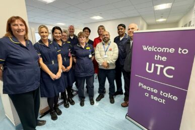 Colleagues stood in the new urgent treatment centre at Yeovil Hospital, next to a purple pull-up banner that says UTC.