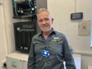 A colleague from Somerset NHS Foundation Trust's digital services team stood in front of a data machine.