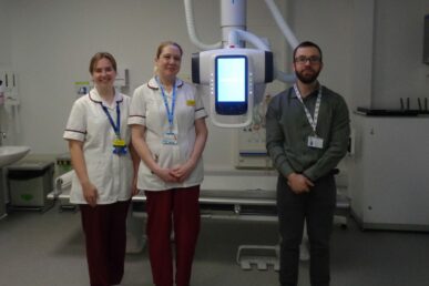 Two radiographers stood in front of an x-ray machine at Minehead Hospital. A representative from Samsung is also in the photo.