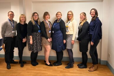Colleagues from the NHS trust's cancer services team stood in a room.