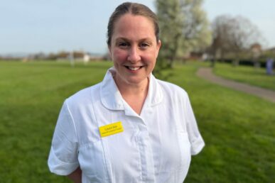 A photo of speech and language therapist Laura Ball in her work uniform standing in a park.