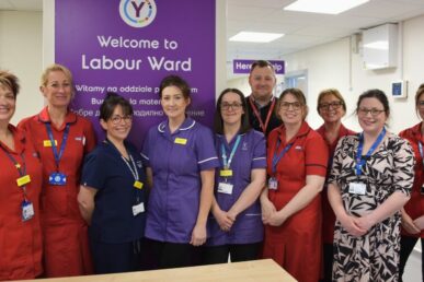 A photo of colleagues from the Yeovil Hospital maternity unit in uniform stood at the entrance to the hospital's Labour Ward.