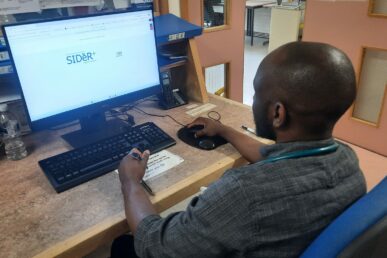 A photo of a doctor sat at a computer.