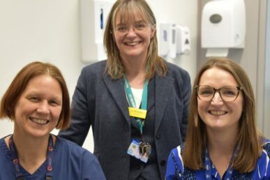 A photo of three colleagues involved in the Postnatal screening study. They are stood in a clinic room.