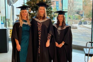 A photo of three NHS colleagues - Jo Doherty - trainee clinical psychologist (now works for another NHS trust), Maisie Knight-Davies - clinical associate psychologist, Freya Gomes - trainee clinical psychologist - stood in their graduation clothing.