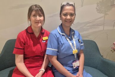 A photo of two nurses sat on a sofa in the Yeovil Hospital Breast Cancer Centre, called The Maple Unit.