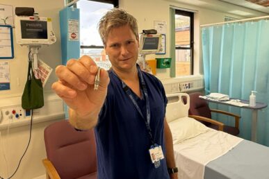 A photo of consultant cardiologist Doctor Guy Furniss holding up a leadless pacemaker device.